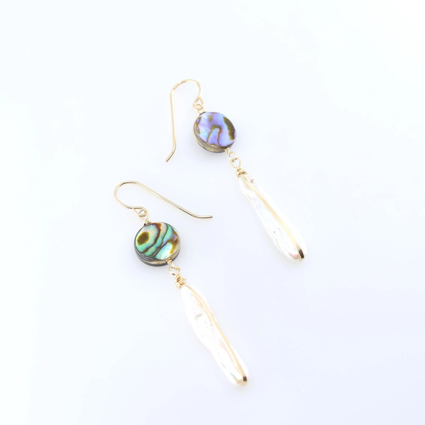 A pair of dangle earrings featuring round, iridescent green and blue Abalone and Biwa Pearl drops, shown on a clean white background.