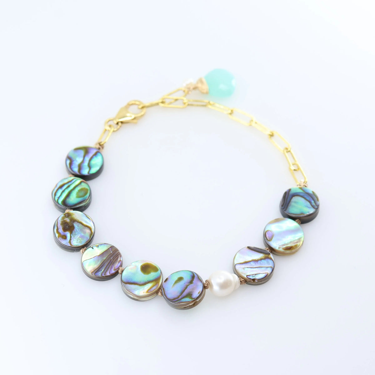 A gold chain bracelet featuring round iridescent abalone shell with shimmering green, blue, and purple hues, accented by a single white pearl bead and a Dark Aqua Chalcedony accent.