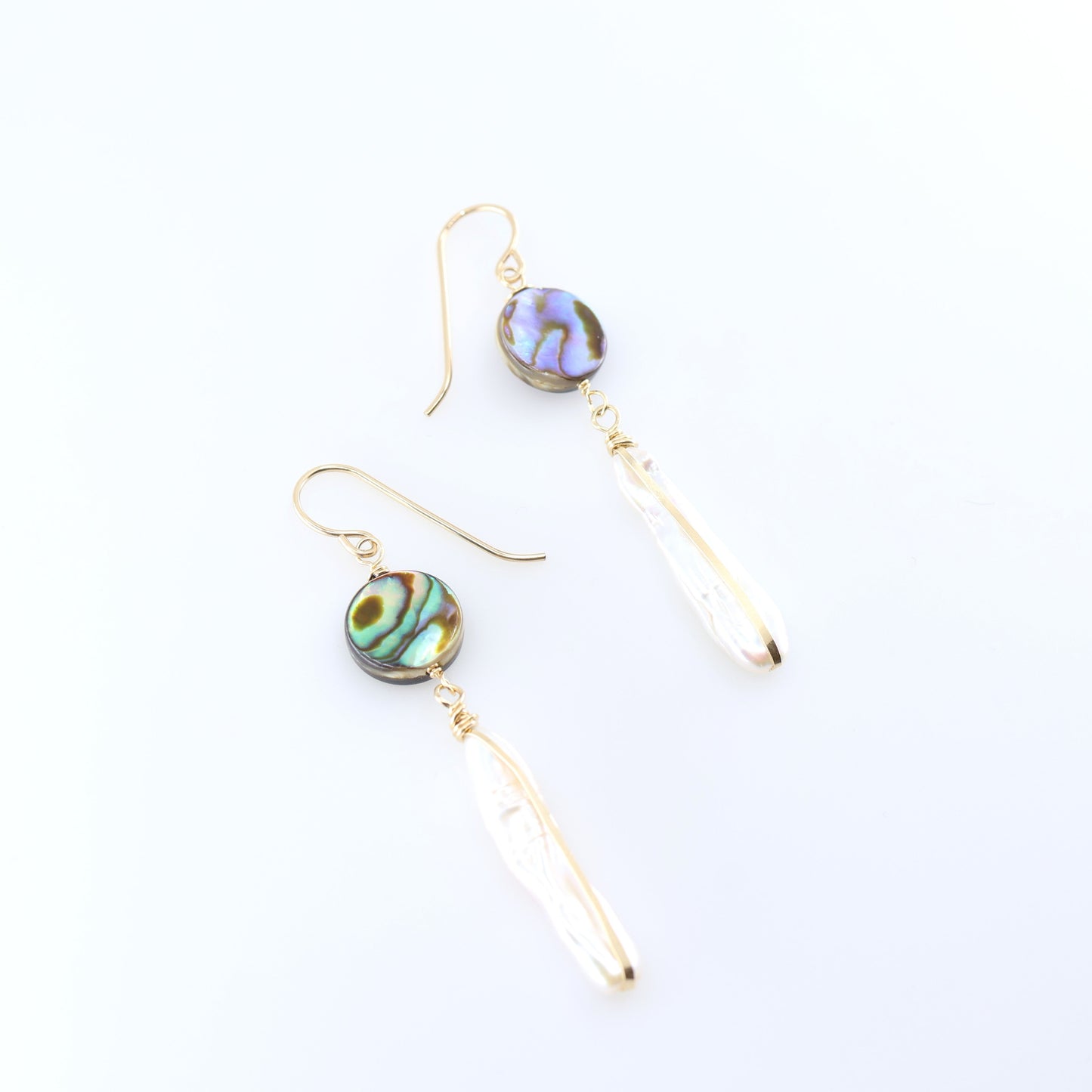 A pair of dangle earrings featuring round, iridescent green and blue Abalone and Biwa Pearl drops, shown on a clean white background.