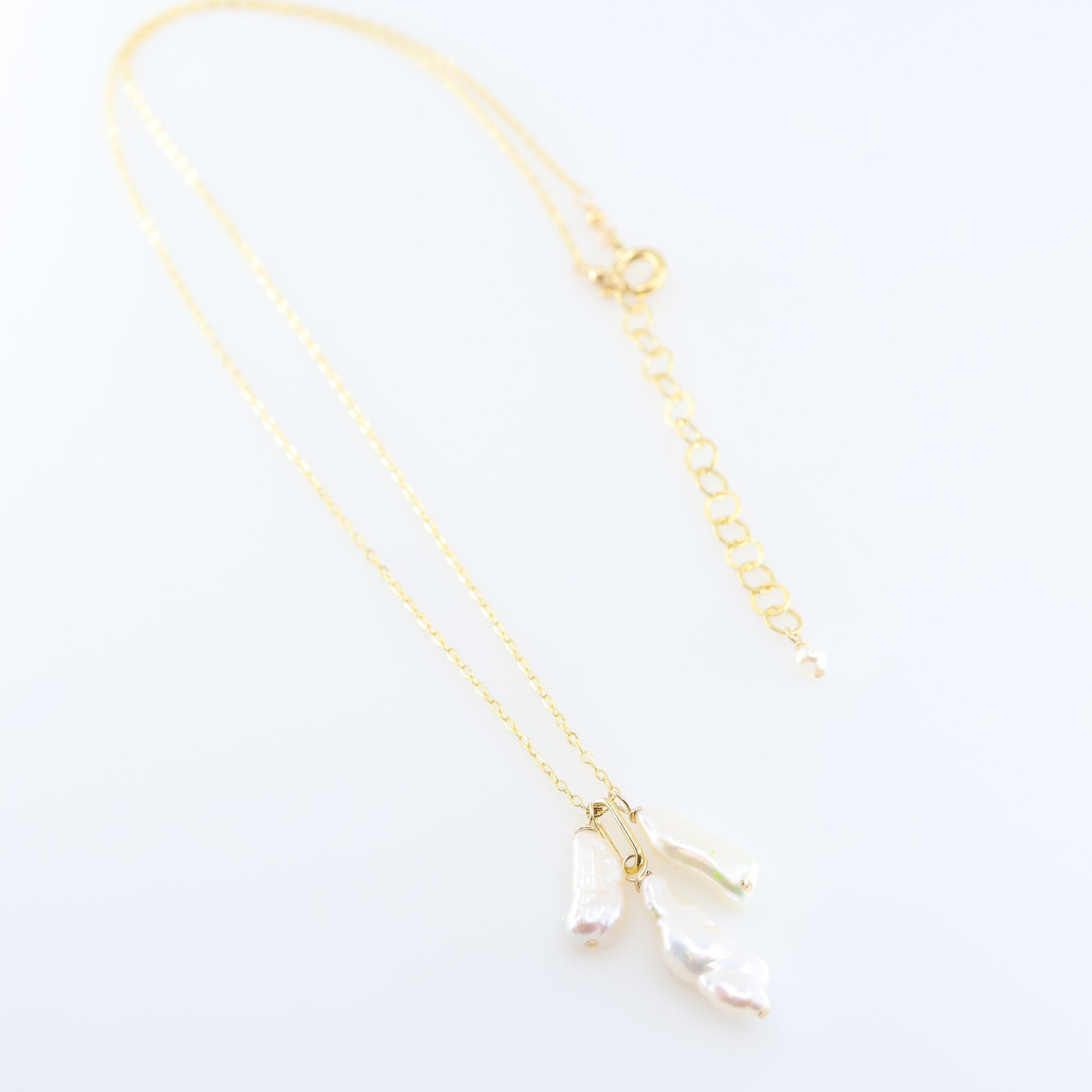 A delicate gold chain necklace featuring three small dangling Biwa Pearl charms, displayed on a clean white background.