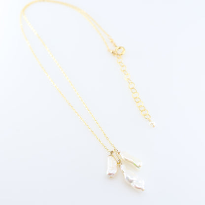 A delicate gold chain necklace featuring three small dangling Biwa Pearl charms, displayed on a clean white background.