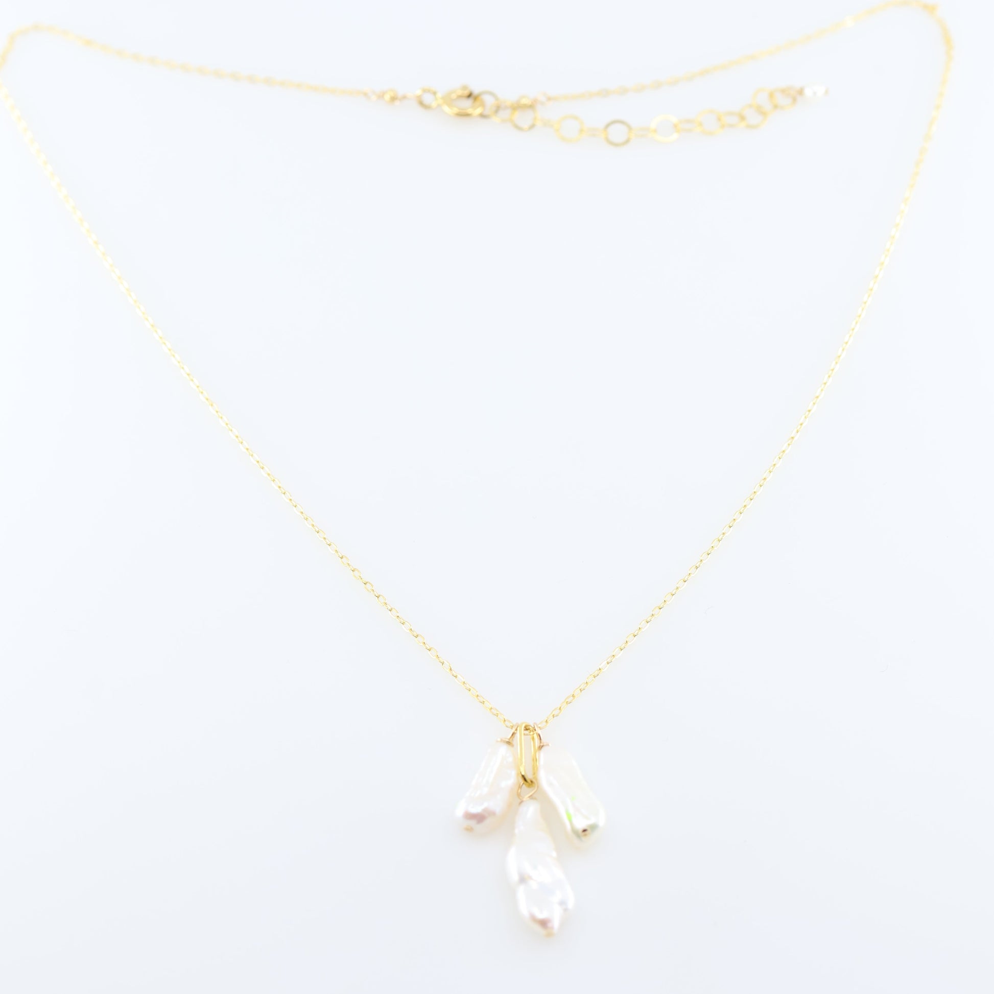 A delicate gold chain necklace featuring three small dangling Biwa Pearl charms, displayed on a clean white background.