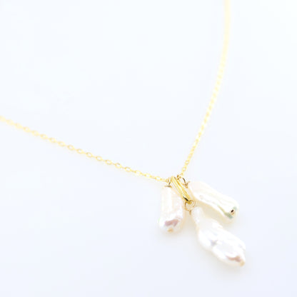 A delicate gold chain necklace featuring three small dangling Biwa Pearl charms, displayed on a clean white background.