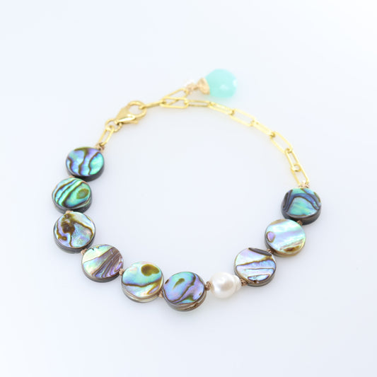 A gold chain bracelet featuring round iridescent abalone shell with shimmering green, blue, and purple hues, accented by a single white pearl bead and a Dark Aqua Chalcedony accent.